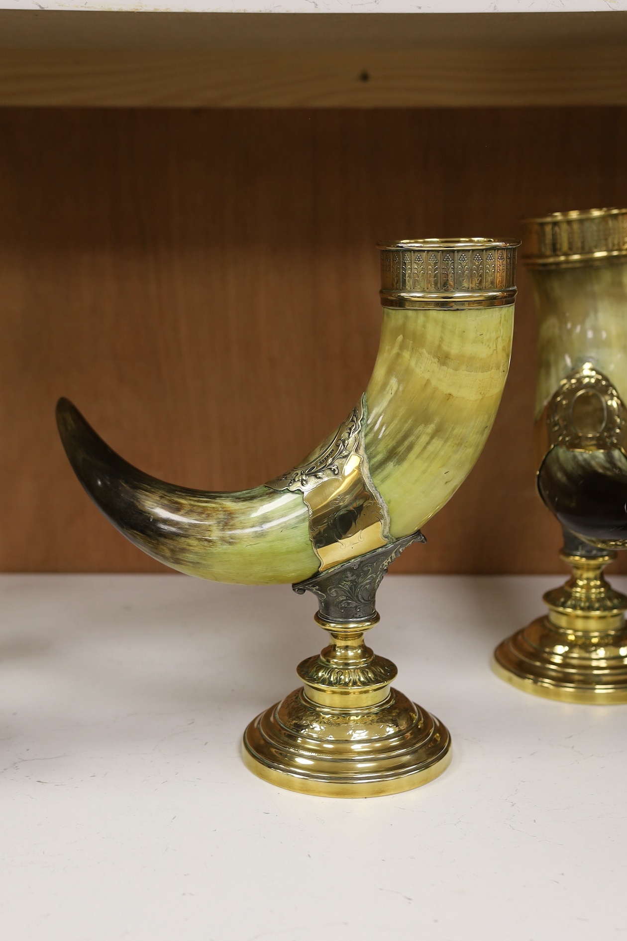 A pair of large decorative brass mounted horns, 33cm high. Condition - brass mounts dented and horns scratched in places